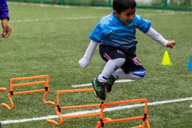 Niños de 5 a 7 años practicando el control del balón con conos