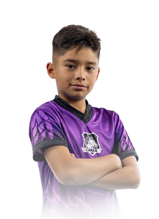 Niño sonriente sosteniendo un trofeo dorado de fútbol en un campo de juego durante el curso de verano de Carax